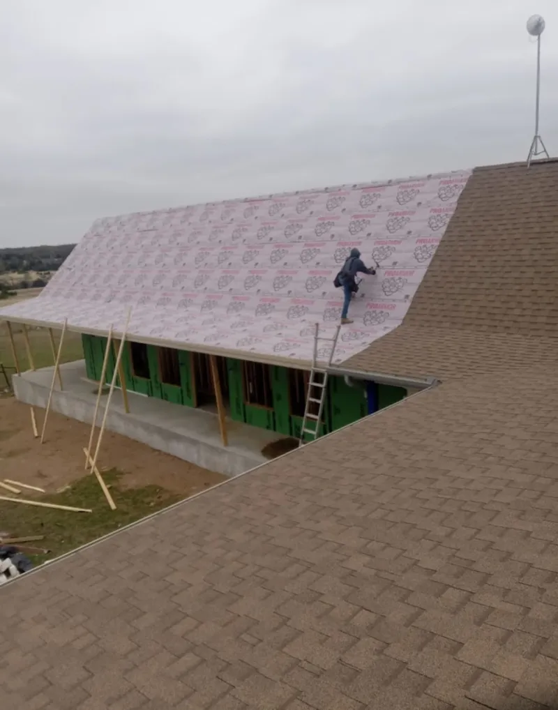 Worker preparing underlayment for a metal roof installation in Pahokee